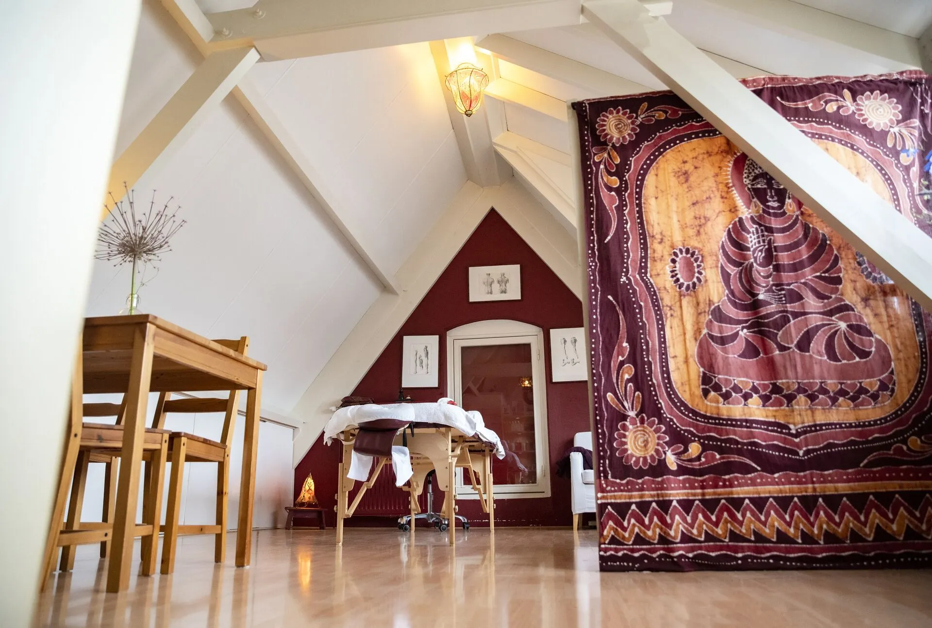 Massagekamer met Boeddhabeeld en warme sfeerverlichting